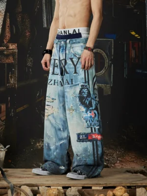 Left front view of distressed graffiti wide-leg jeans with ocean-blue washed denim, bold lettering, ripped details, and vintage streetwear patches