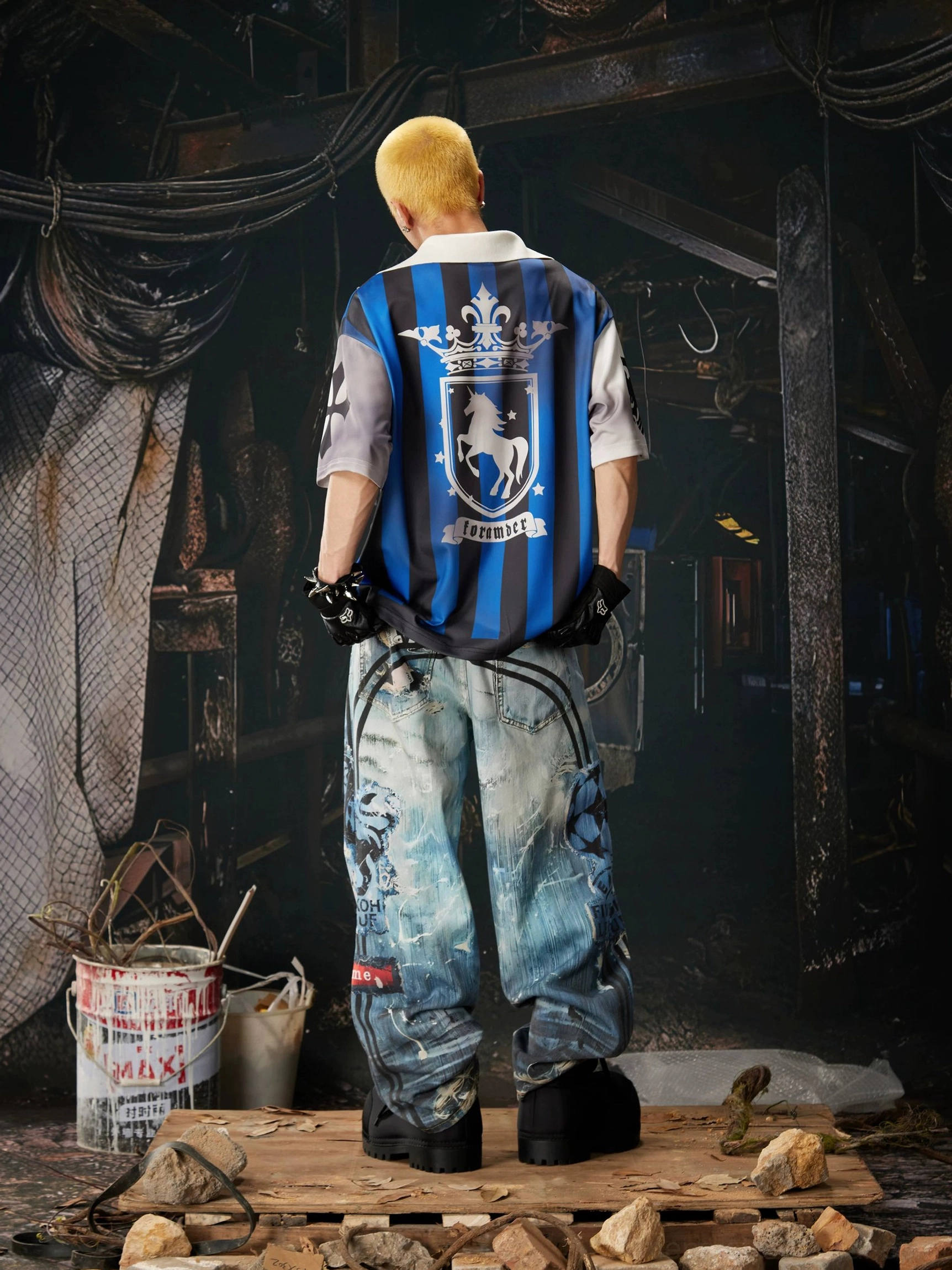 Distressed graffiti wide-leg jeans in ocean-blue washed denim with bold streetwear graphics, vintage patch effects, and relaxed oversized shape