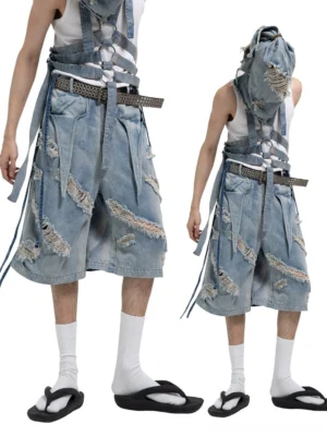 Front and back studio views of vintage blue distressed harness strap denim Bermuda shorts with wide legs and frayed ripped details