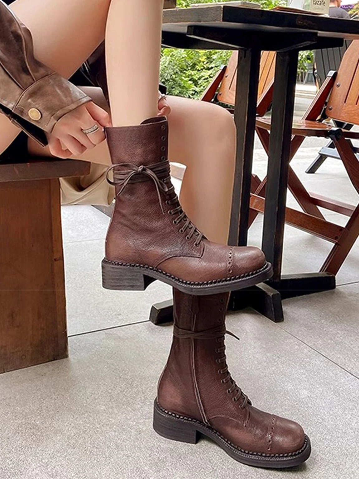 Stacked dark brown distressed leather combat boots showing low block heel sole thickness and textured coated leather