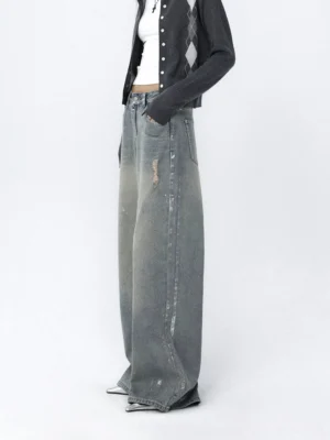 Side view of faded light blue wide-leg jeans featuring distressed streaks, relaxed denim construction, and a long floor-skimming leg