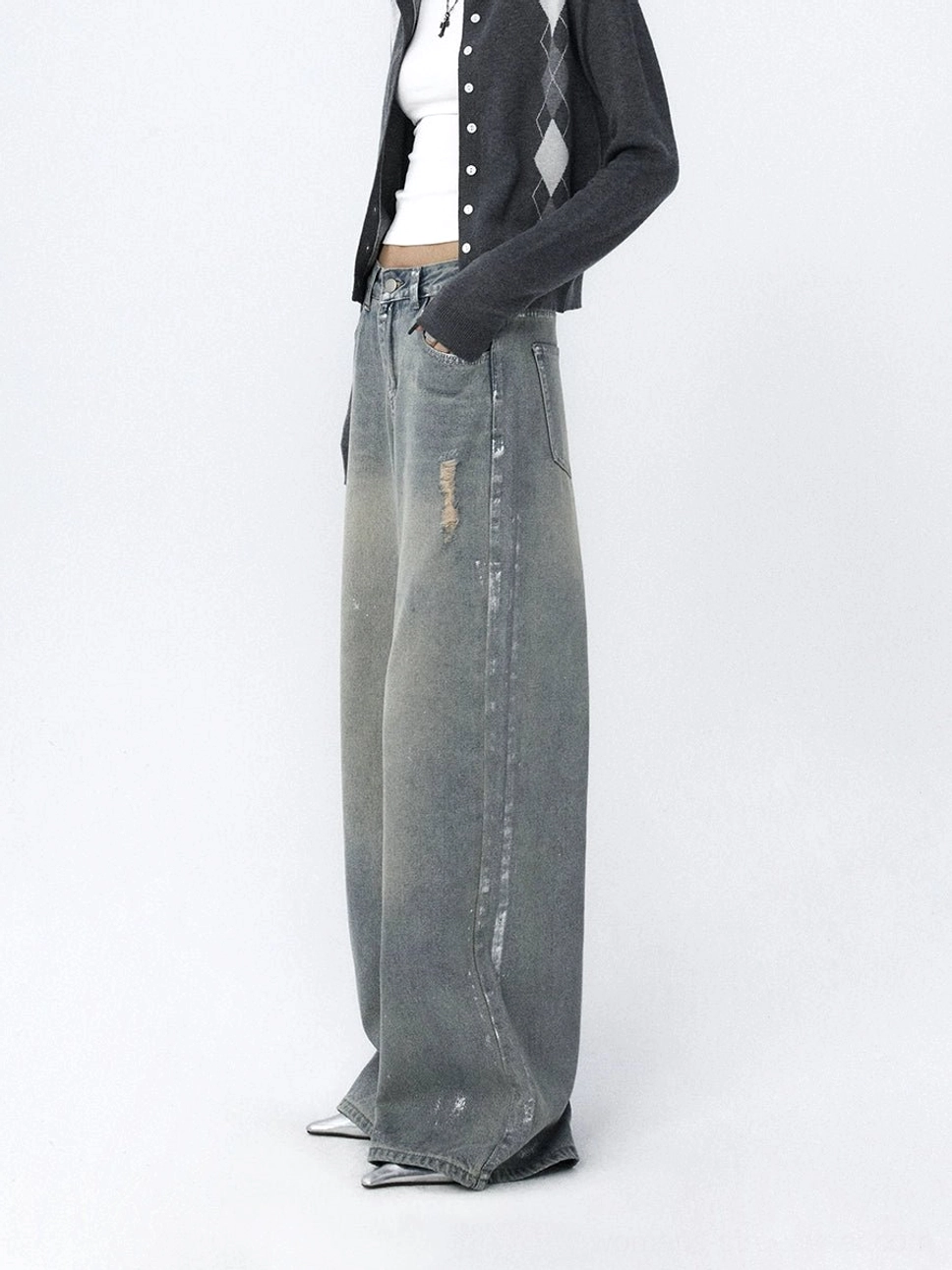 Side view of faded light blue wide-leg jeans featuring distressed streaks, relaxed denim construction, and a long floor-skimming leg