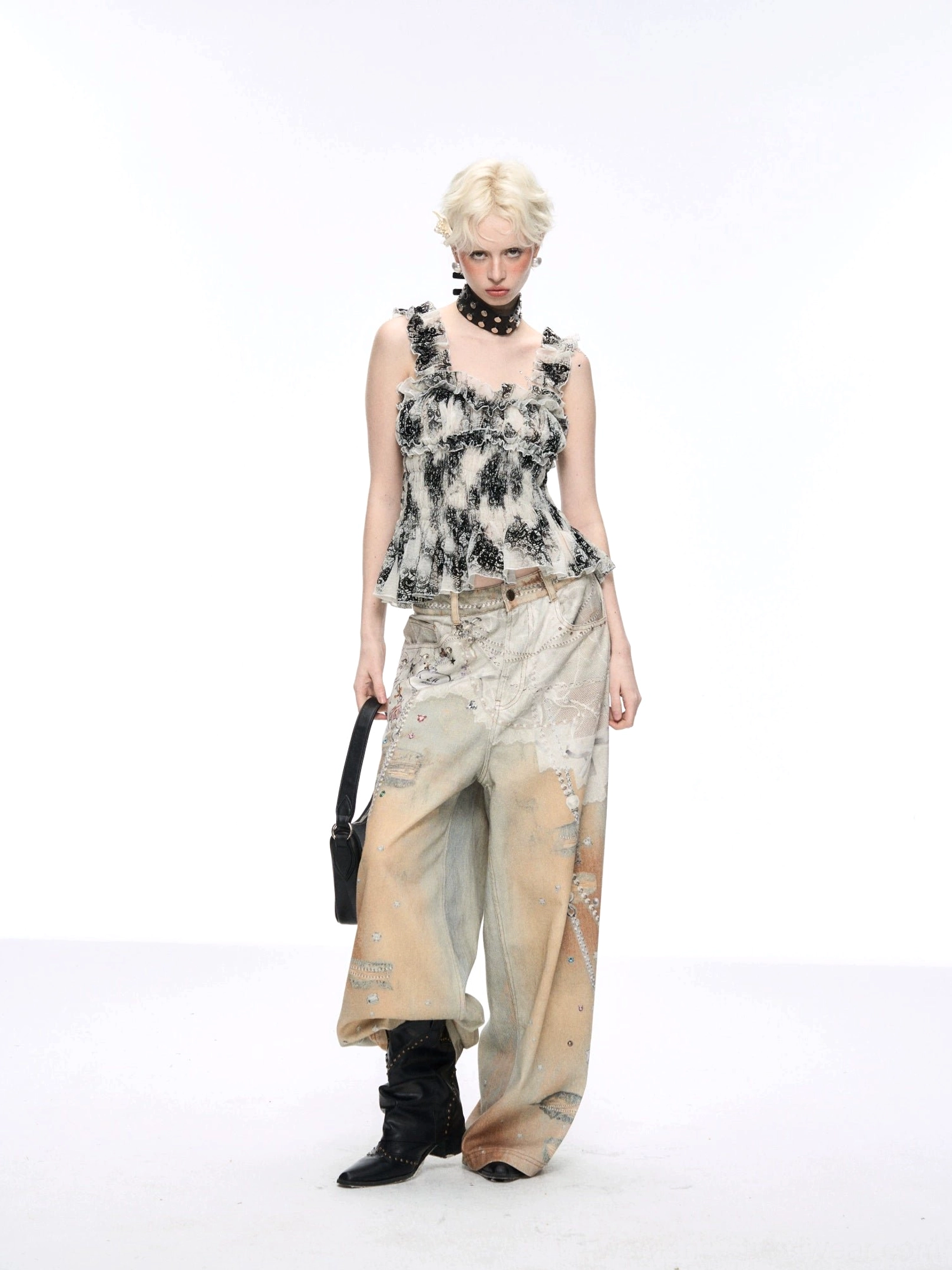 Full length front view of distressed painted chain wide-leg jeans styled with black ankle boots for an alternative streetwear outfit