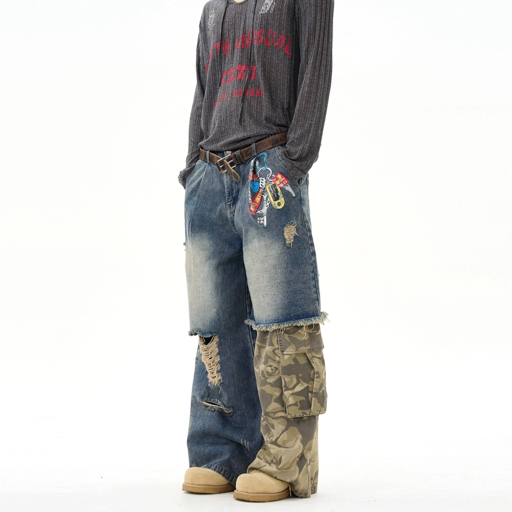 Distressed patchwork wide-leg jeans in vintage washed blue denim with camo cargo panels, frayed ripped details, and relaxed streetwear styling