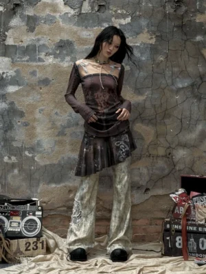 Front full-body view of a model wearing dark white distressed rose embroidered flare pants with black platform shoes
