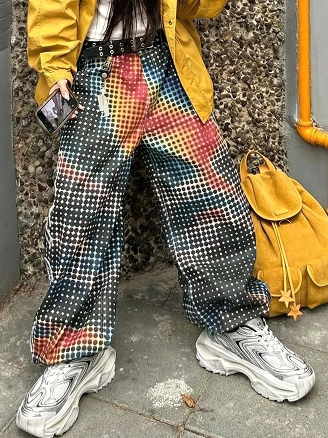 Distressed silver chunky dad sneakers styled with yellow outerwear and gradient checkered pants in an outdoor streetwear look