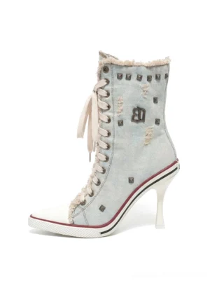Light blue distressed studded denim platform stiletto boots with lace-up front, raw edges, and white toe caps