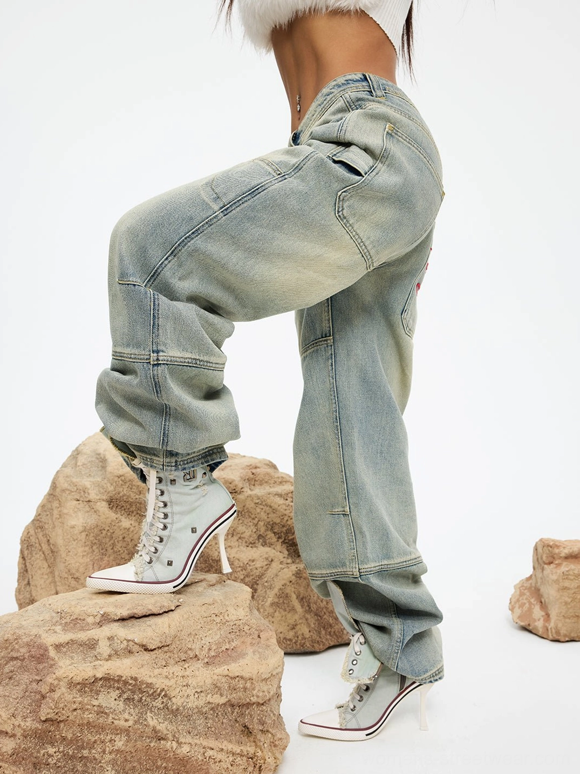 Rear three-quarter styling view of denim platform stiletto boots worn with loose vintage jeans