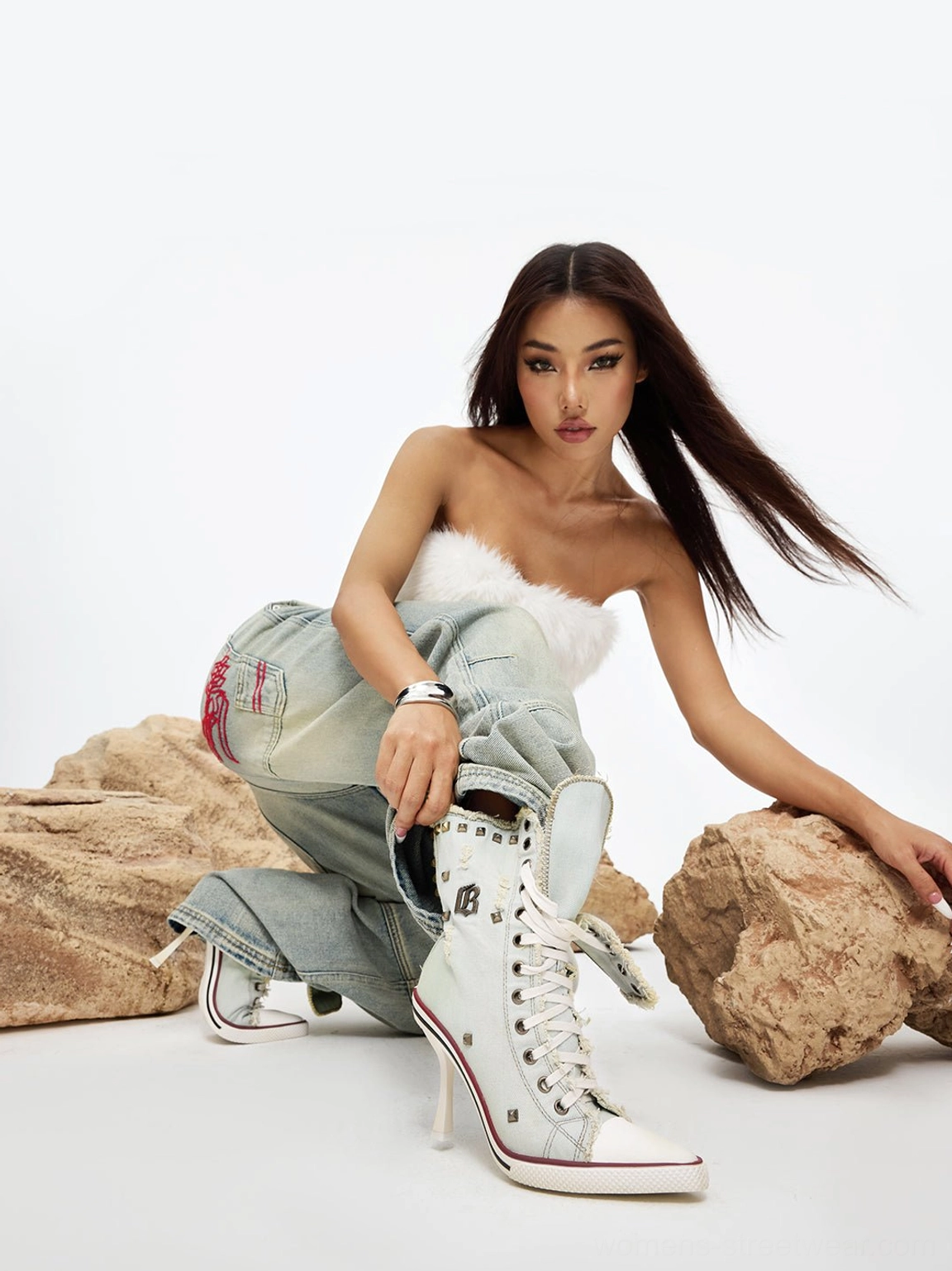 Model styling distressed studded denim platform boots with vintage jeans for a streetwear-inspired look