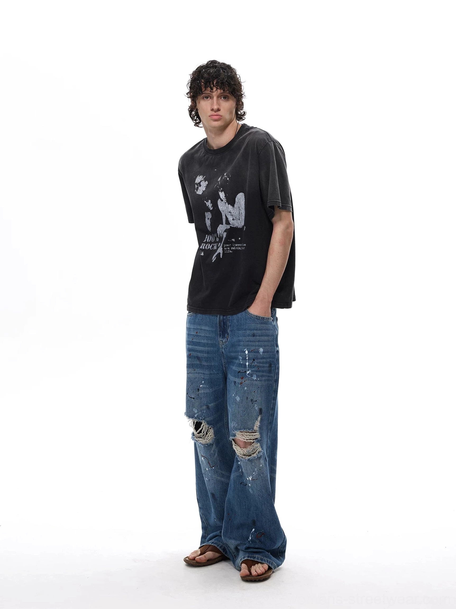 Three-quarter side view of distressed wide-leg denim jeans with loose grunge silhouette and frayed knee openings