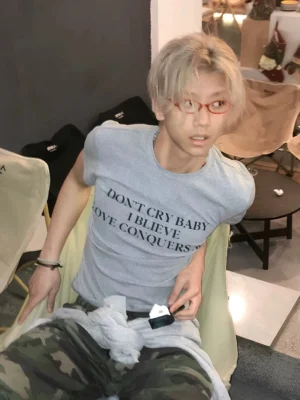 Light gray Don't Cry Baby slogan T-shirt in a slim fit styled with camo cargo pants in an indoor mirror streetwear look
