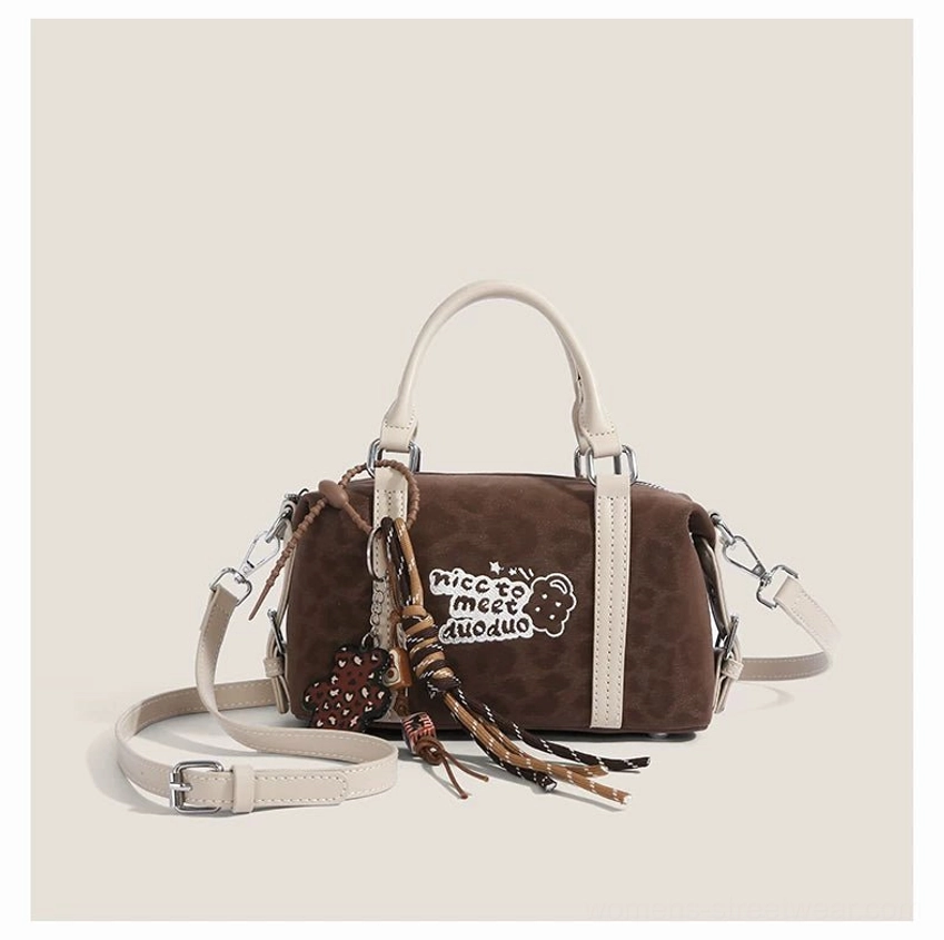Dark brown leopard print mini barrel bag with off-white handles, embroidered bear patch, pendant tassel and detachable strap