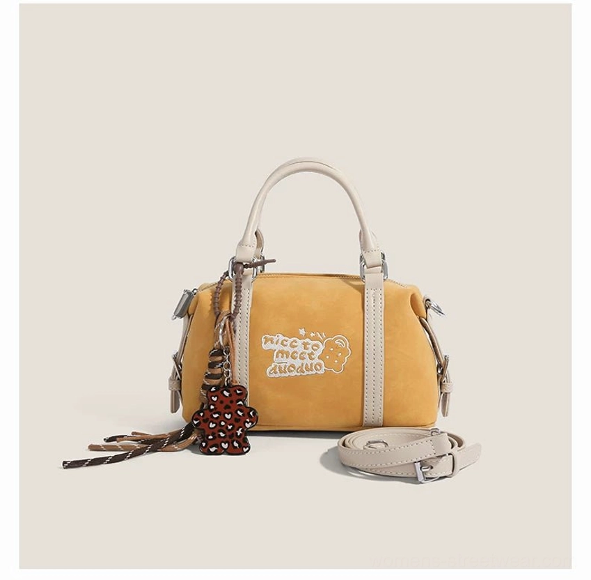 Frosted yellow Doodle Charm mini barrel bag with off-white trim, embroidered bear detail, tassel charm and detachable shoulder strap
