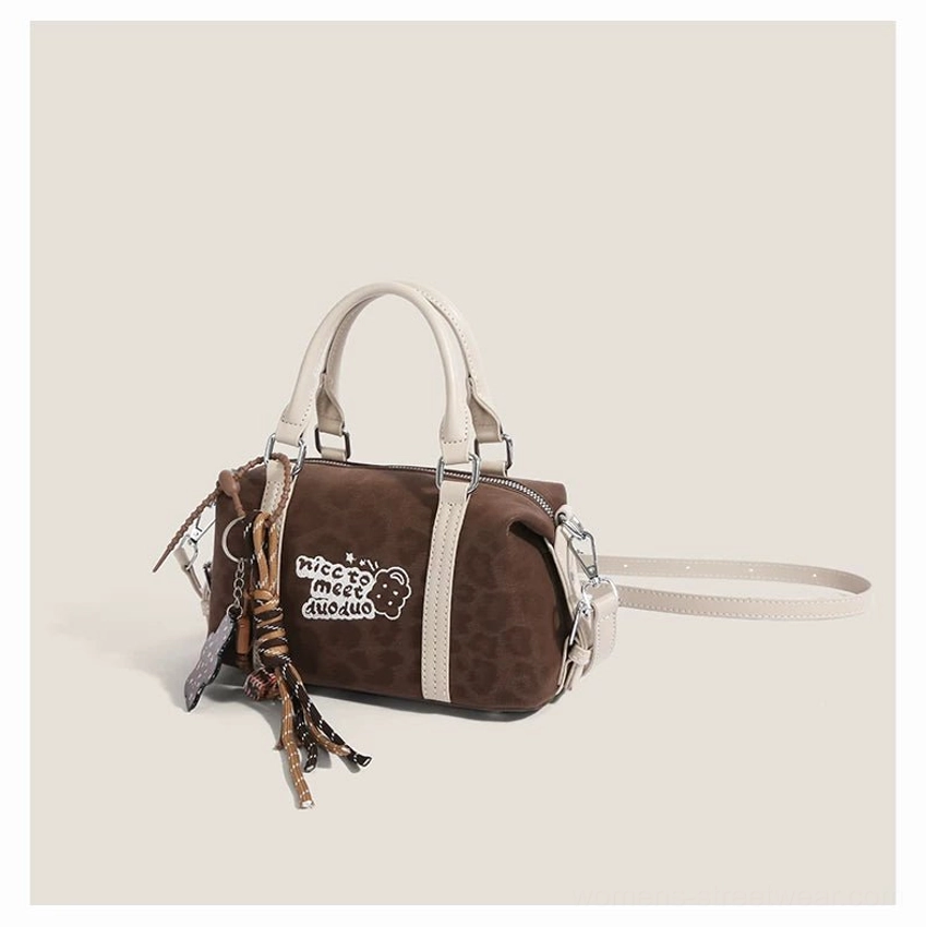 Leopard print brown mini Boston bag displayed with off-white trim, top handles, bear embroidery, tassel pendant and shoulder strap