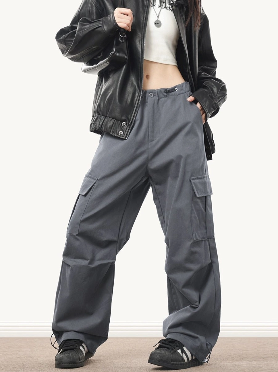 Dark gray wide-leg streetwear cargo pants with a relaxed baggy silhouette, adjustable drawstring waist and side utility pockets