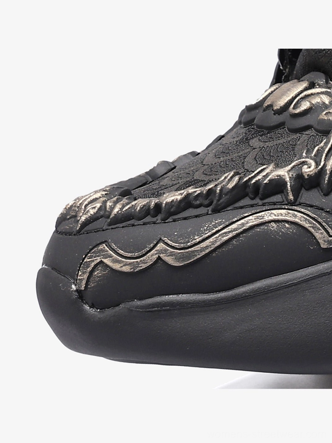 Black chunky dragon runner shoes with a raised crest design, decorative color accents, lace-up front, and substantial contemporary streetwear sole