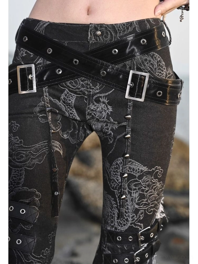 Close up of black dragon flare jeans waist and hip with crossed leather buckle belts, metal studs, dragon graphics, and adjustable leg straps