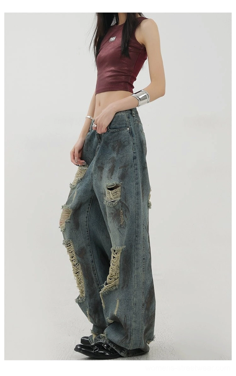 Side rear view of draped wide-leg distressed jeans featuring faded dirty wash details and relaxed streetwear styling
