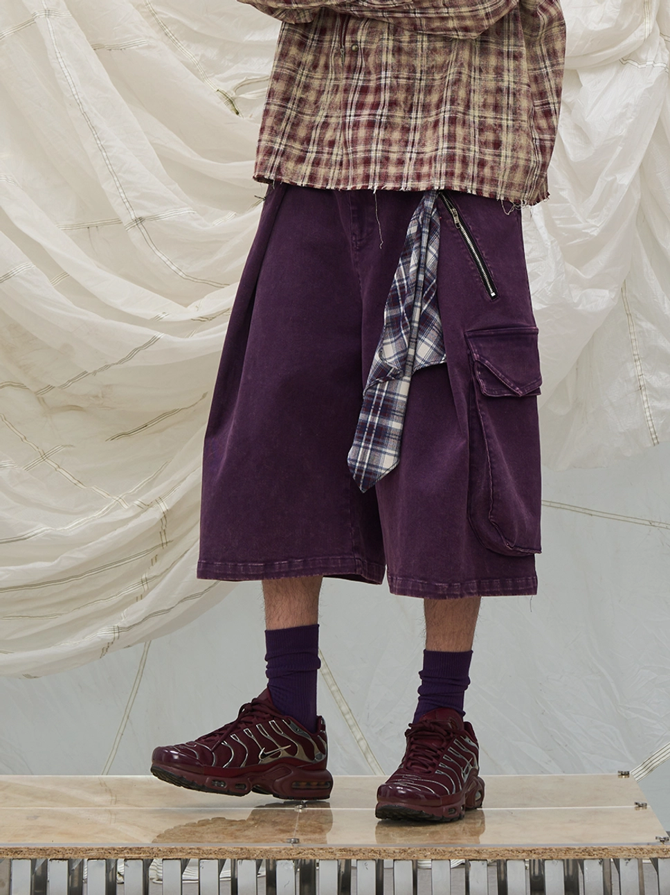 Purple washed cargo culotte shorts with oversized wide legs, side cargo pockets, and decorative plaid scarf detail