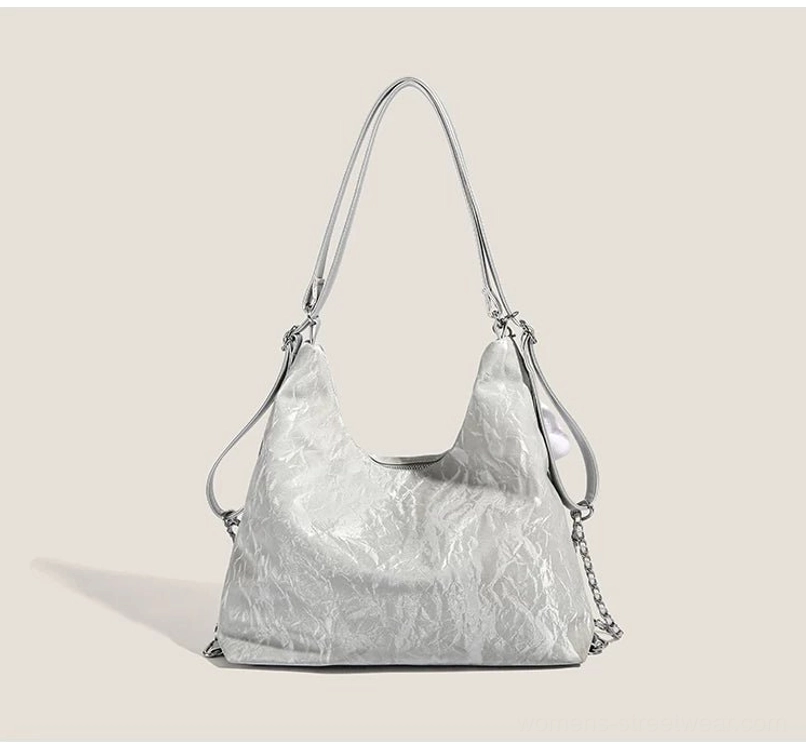 Silver dreamy butterfly slouchy hobo shoulder bag front flat view with cloud pendant and dual carrying straps