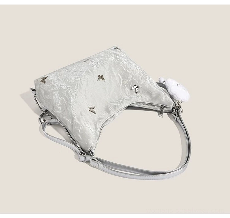 Silver slouchy hobo shoulder bag rear view showing flat bottom detachable strap cloud plush charm and zipper detail