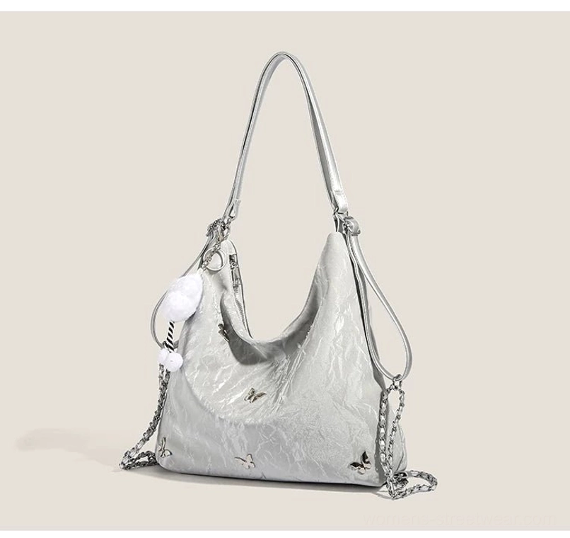 Silver cloud charm butterfly slouchy hobo shoulder bag with metallic butterfly accents and glossy crinkled exterior
