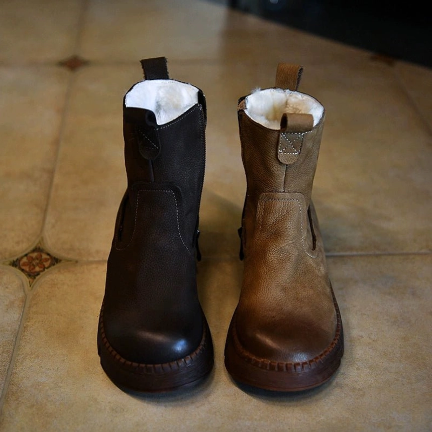 Dual-tone brown winter shearling boots displayed from the front with distressed leather panels, plush collars, and chunky lug soles