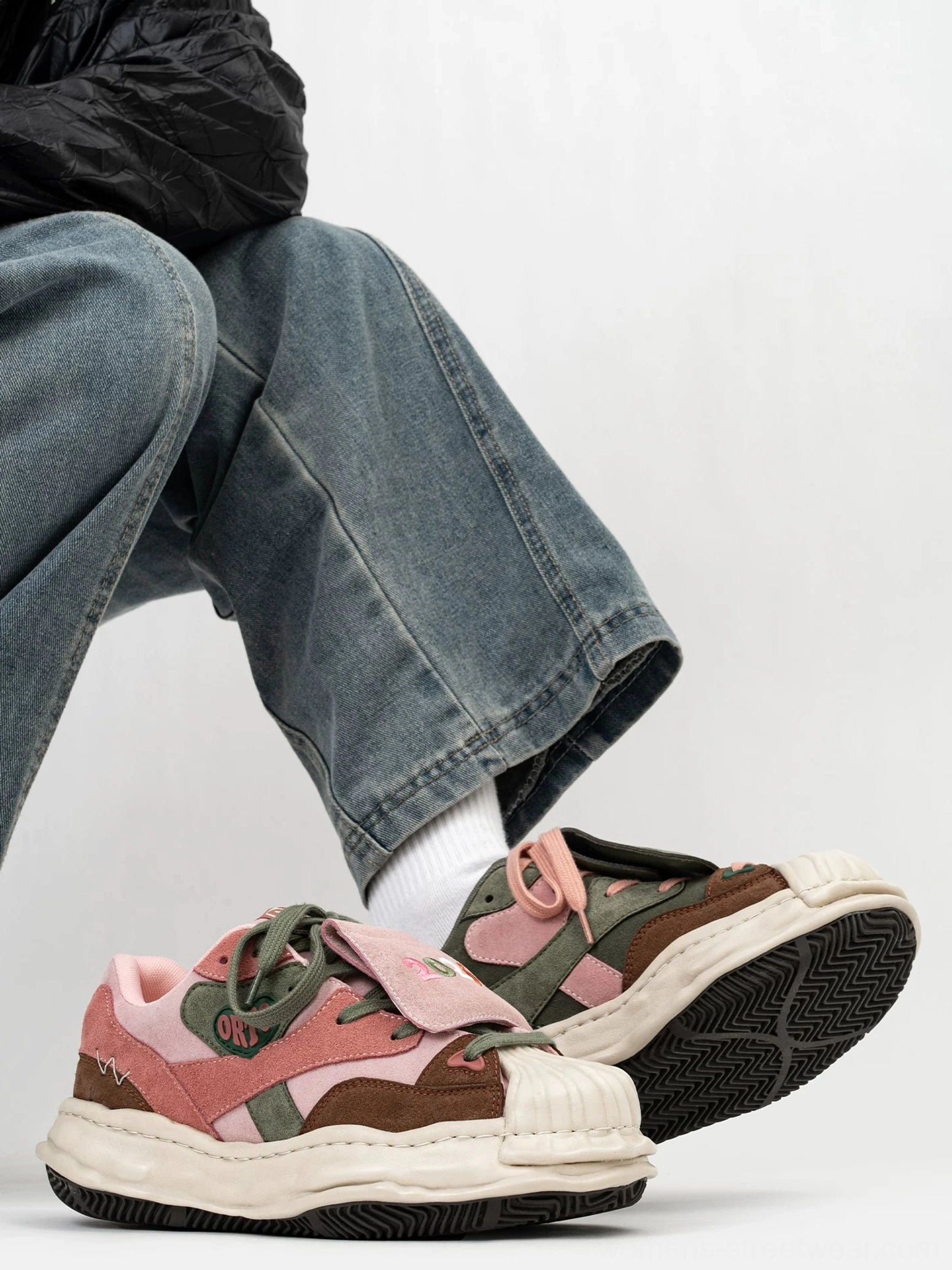 Worn duckling patch low top sneakers with colorful suede-style panels, off-white chunky soles, denim jeans, and white socks