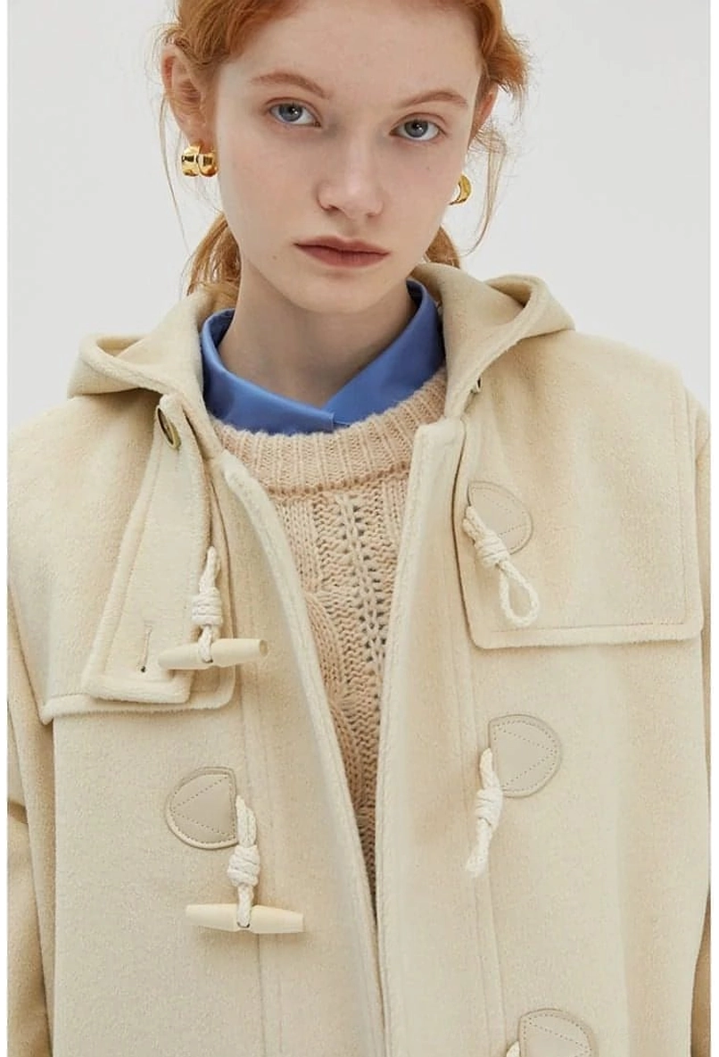 Model wearing duffle coat from back view showing hood silhouette and overall construction