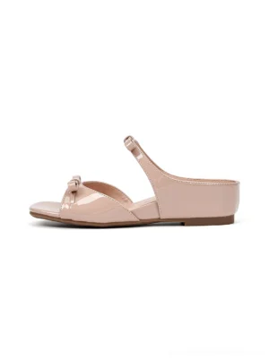 Dusty pink bow wedge slide sandals with glossy patent-style straps, open square toe, and low wedge heel shown in a side view