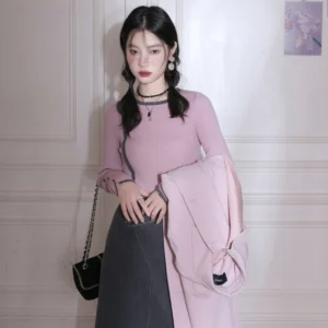 Dusty pink ribbed long sleeve knit top styled with dark gray midi skirt and light pink coat
