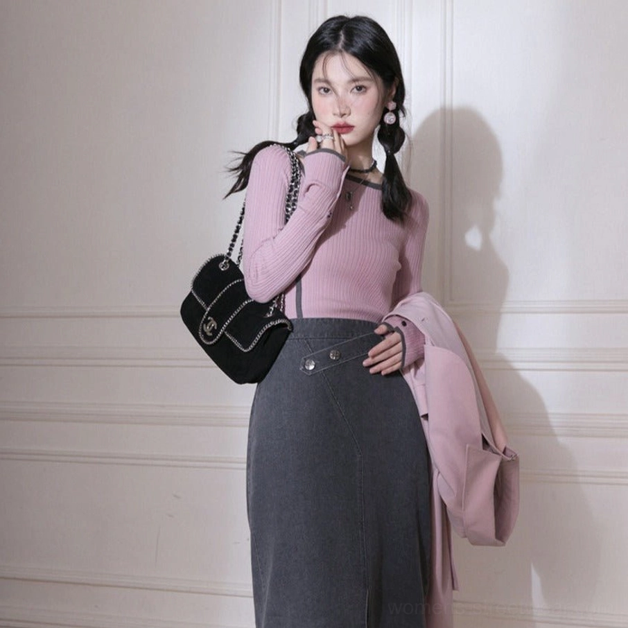 Side view of dusty pink fitted ribbed knit top with buttoned cuffs and dark contrast binding