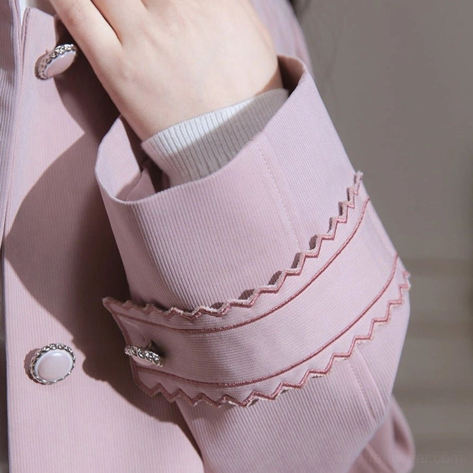 Close-up of scalloped cuff trim pearl-finish button and ribbed inner cuff on dusty pink trench coat