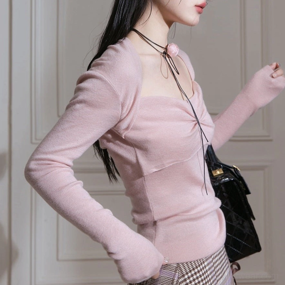 Close up of dusty pink fitted knit top with twisted bust detail extended sleeve cuffs and square neckline