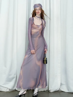 Dusty purple sheer satin maxi dress with square neckline, fitted floor-length silhouette, long mesh sleeves, and mini black handbag