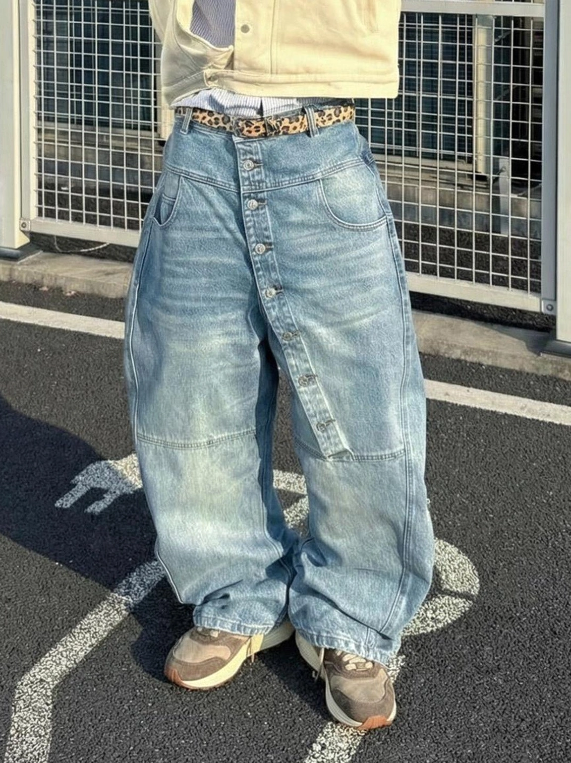 Earth tone retro trail runner sneakers styled with relaxed denim jeans in an outdoor streetwear outfit
