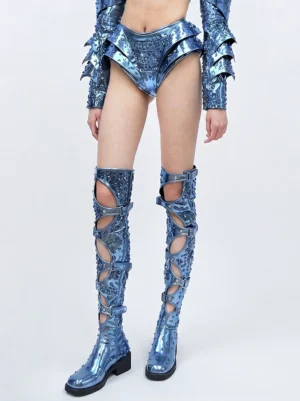 Electric blue cutout over-the-knee boots styled with a matching metallic outfit, showing buckle straps and block heels