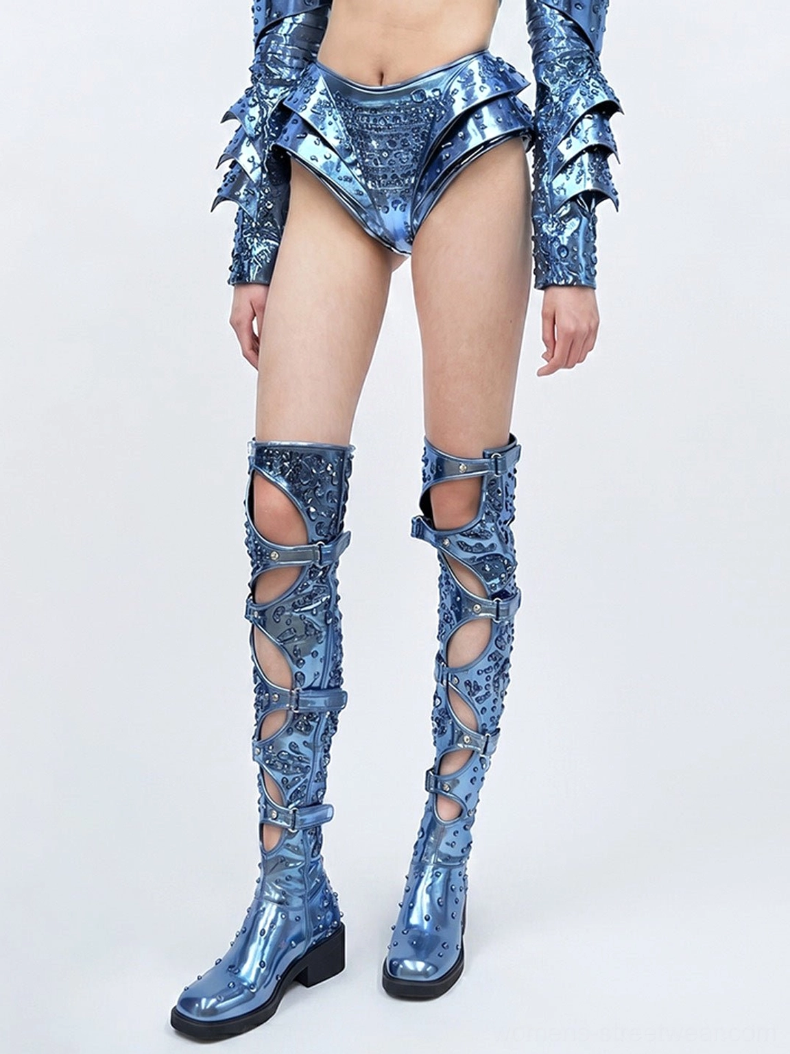 Electric blue cutout over-the-knee boots styled with a matching metallic outfit, showing buckle straps and block heels