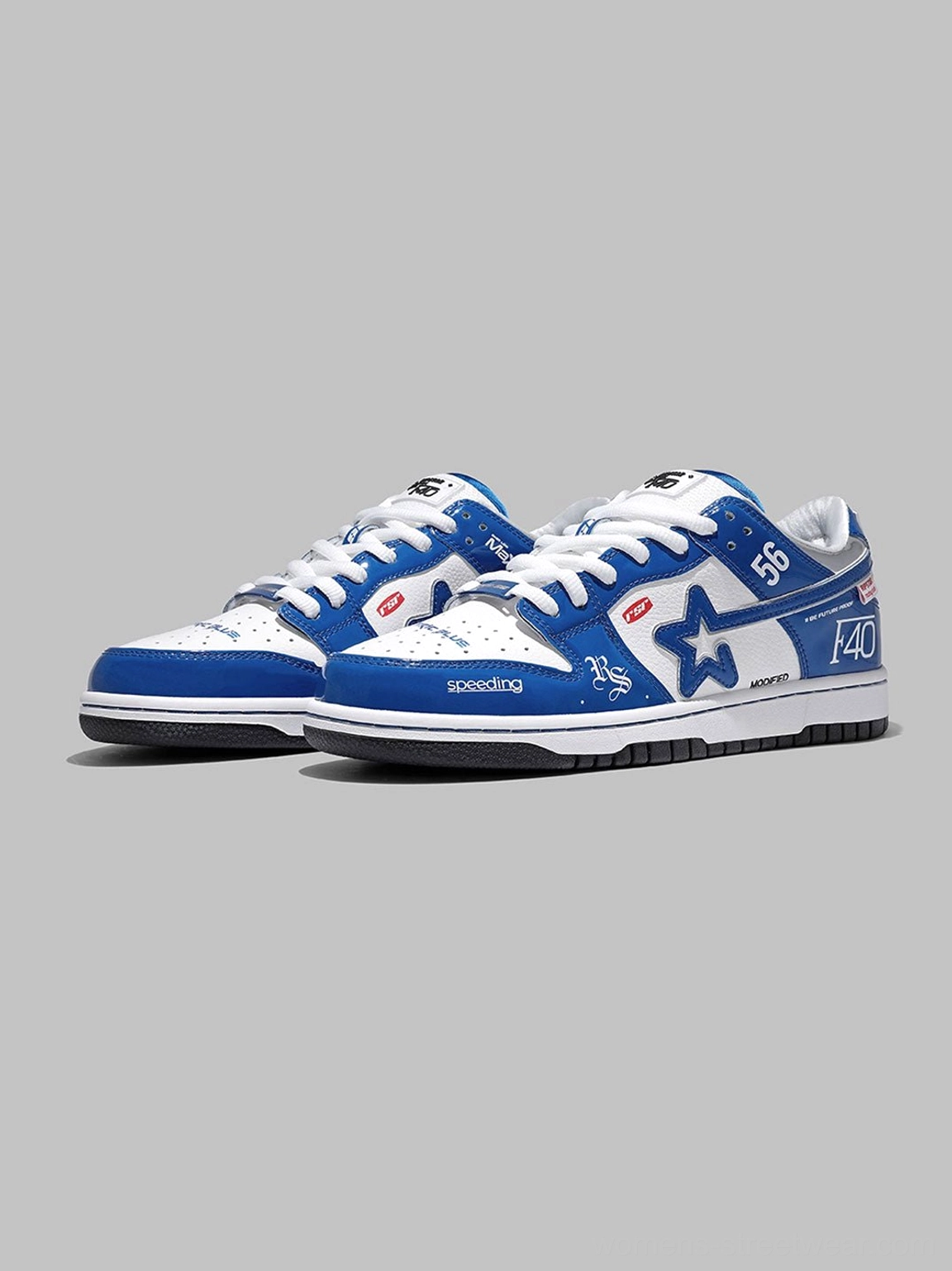 Front view of electric blue and white low-top retro racing sneakers with star artwork, graphic lettering, and classic thick skate sneaker outsole