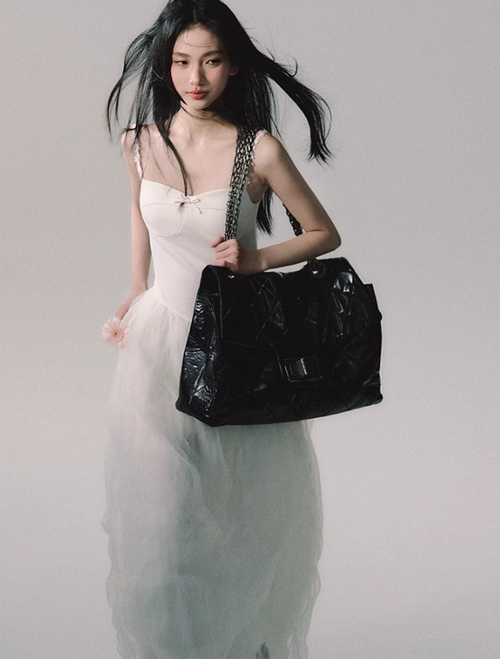 Elegant white tulle gown featuring a fitted bodice, sweetheart neckline, satin bow accent, and flowing formal skirt