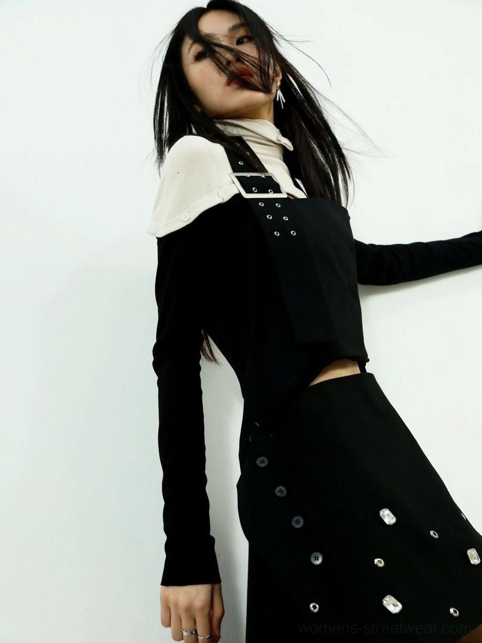 Close-up of the black overlay and cream fitted body on the two-tone high-neck streetwear knit top