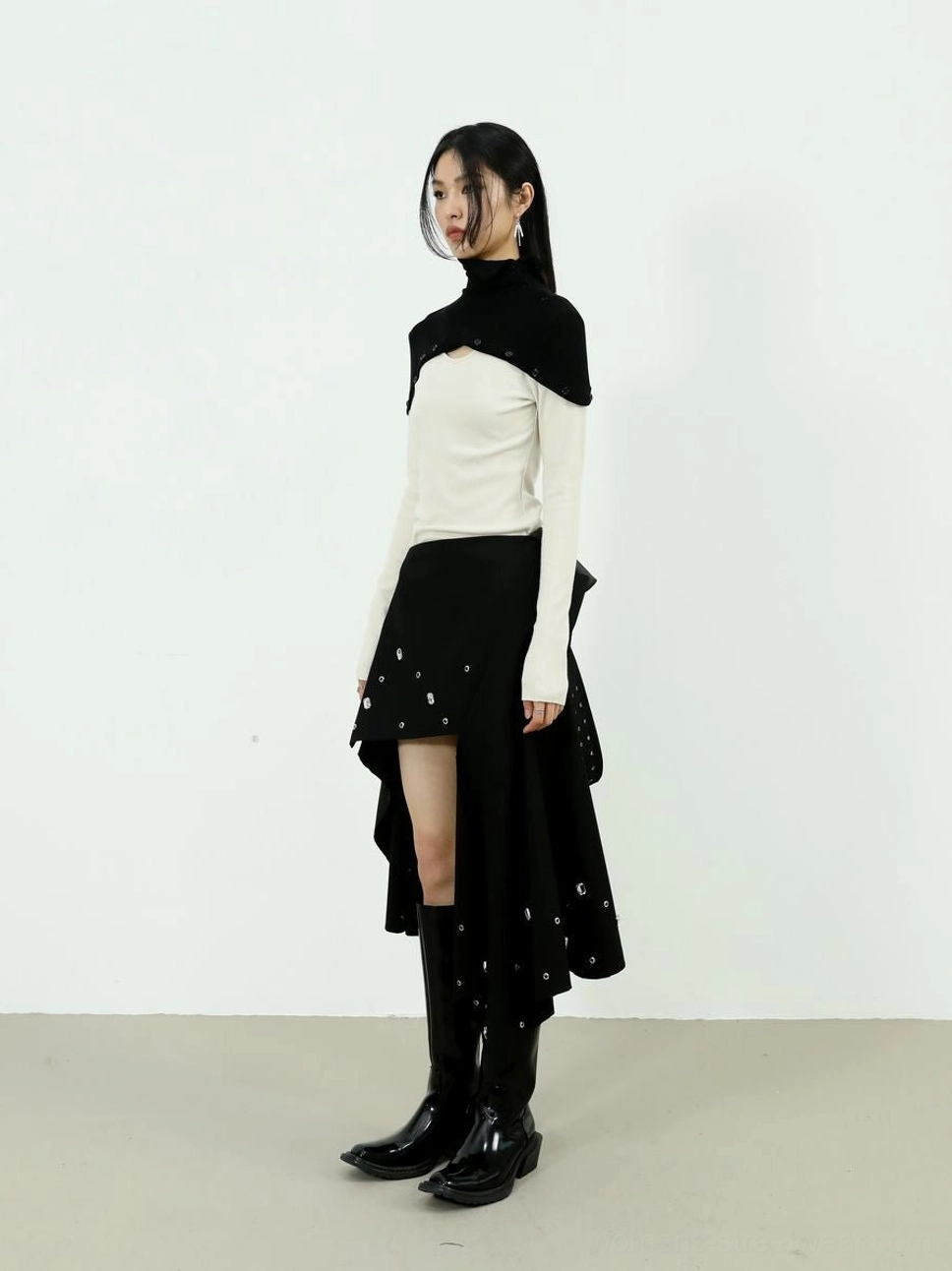 Side view of the Elevate black and cream high-neck layered knit top in a modern Seoul fashion outfit