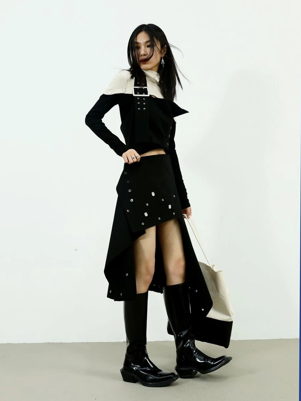 Three-quarter view of high-neck black and cream color-block knit top styled in an Acubi-inspired outfit