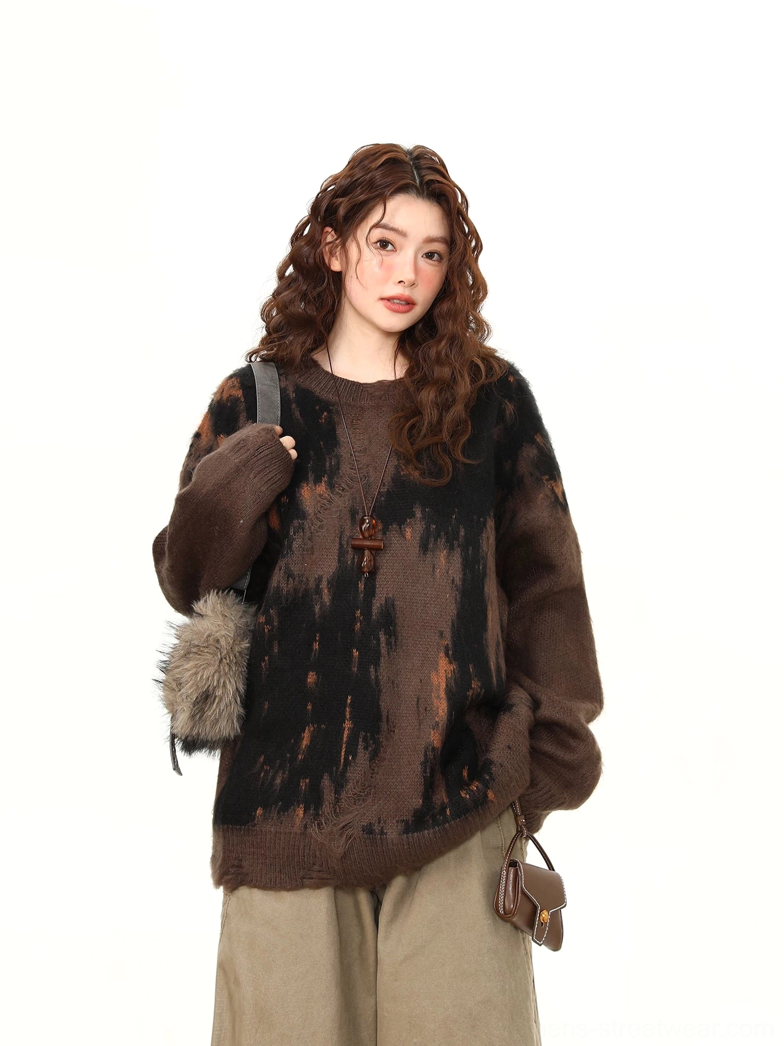 Three quarter side view of dark brown abstract brushstroke oversized sweater showing dropped shoulders and distressed raw hem