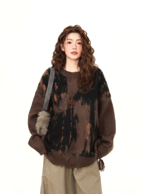 Front upper body view of oversized dark brown brushstroke knit sweater with black and rust orange abstract flame pattern