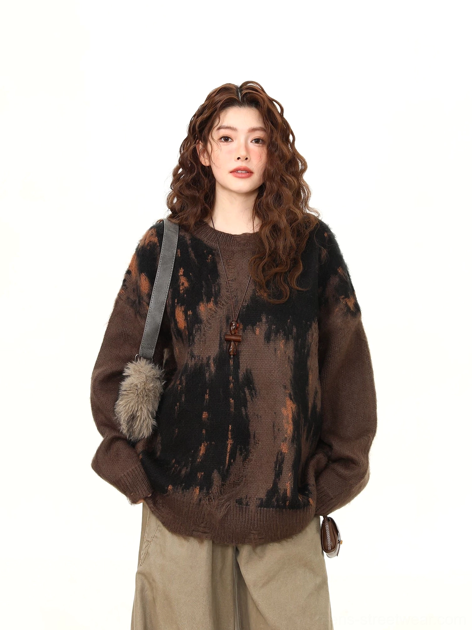 Front upper body view of oversized dark brown brushstroke knit sweater with black and rust orange abstract flame pattern
