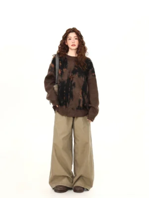 Full front view of oversized brown distressed hem brushstroke knit sweater styled with khaki wide leg pants and loafers