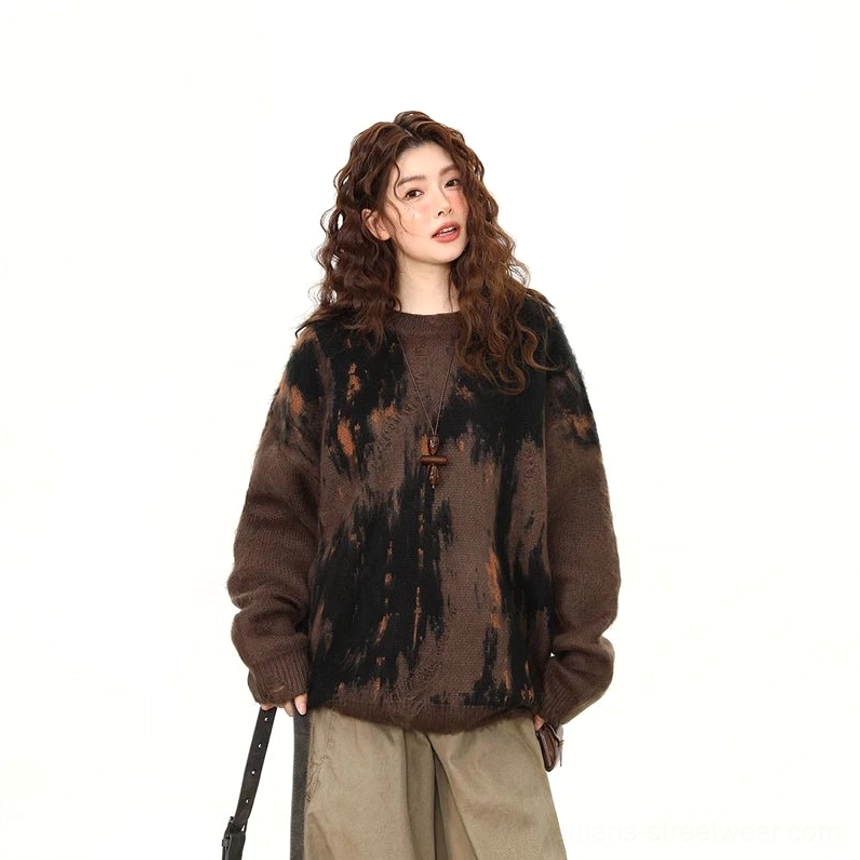 Front half body view of oversized dark brown knit sweater with black and orange abstract brushstroke design