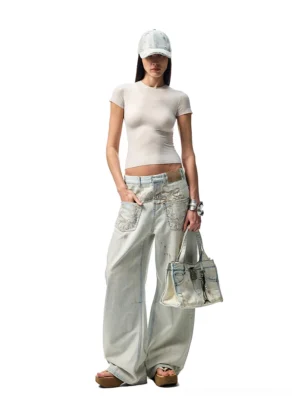 Female model wearing embroidered distressed wide-leg jeans with a cropped fitted tee, baseball cap, and denim tote in a Korean streetwear outfit