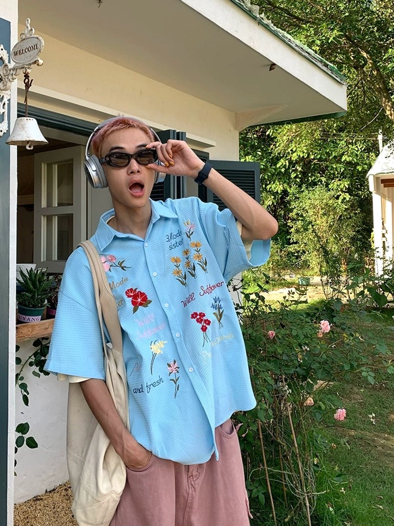 Sky blue embroidered floral waffle shirt with short sleeves and playful text details styled in a relaxed Korean streetwear outfit